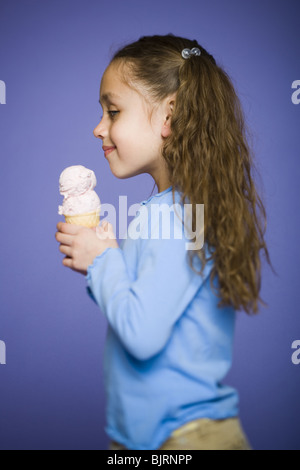 Profil d'une jeune fille tenant un cornet de crème glacée Banque D'Images