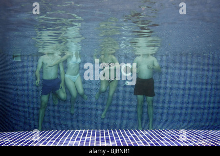 Photo sous-marine de personnes ayant l'amusement dans la piscine Banque D'Images