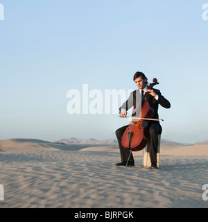 USA, Utah, little Sahara, young man with cello in desert Banque D'Images