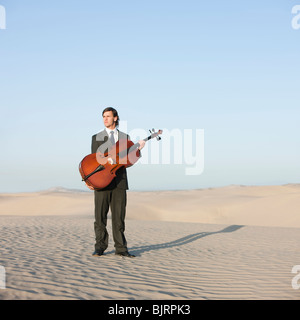 USA, Utah, little Sahara, young man with cello in desert Banque D'Images