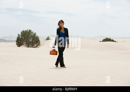 USA, Utah, little Sahara, young businesswoman walking on desert transportant du gaz peut Banque D'Images