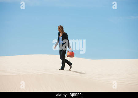 USA, Utah, little Sahara, young businesswoman walking on desert transportant du gaz peut Banque D'Images