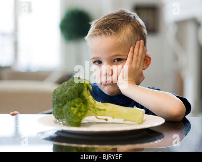 USA, Utah, Alpine, boy (6-7) bouder par table avec plaque de brocoli Banque D'Images