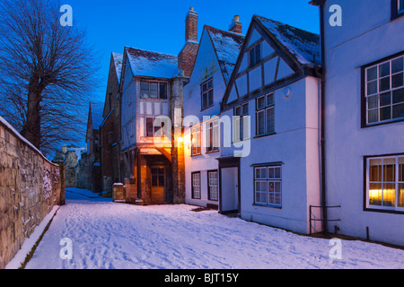 Le crépuscule tombe sur neige de l'hiver et des maisons médiévales Millers Green à côté de la cathédrale de Gloucester UK Banque D'Images