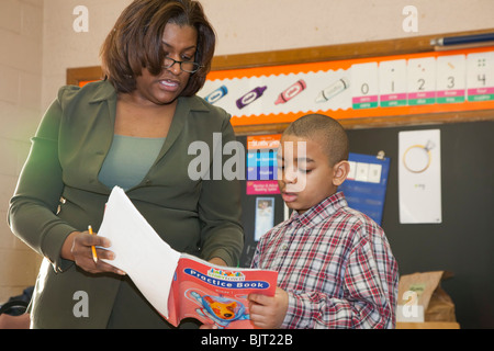 Detroit, Michigan - première année d'enseignant Ivy Bailey aide un étudiant à l'école primaire de MacDowell. Banque D'Images