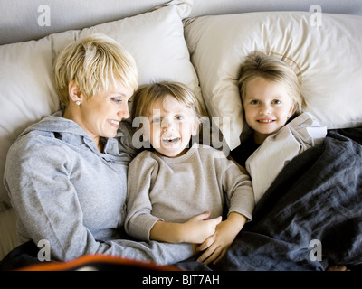 USA, Utah, Provo, Boy and girl (2-5) in bed with mother Banque D'Images