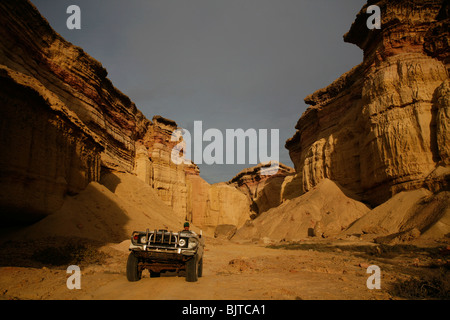 Une voiture conduit hors de la magnifique canyons qui courent le long de la côte de Namibe. La province de Namibe, dans le sud de l'Angola. Banque D'Images