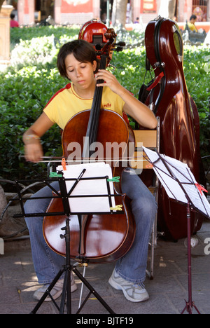 Les jeunes femmes étudiant en musique à jouer du violoncelle en El Jardin, San Miguel de Allende, Guanajuato, Mexique Banque D'Images