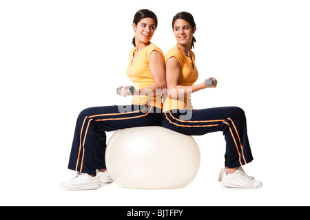 Sisters sitting on yoga ball Banque D'Images