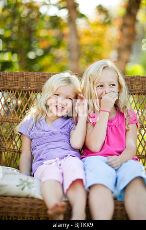 Soeurs assis sur son fauteuil de jardin Banque D'Images