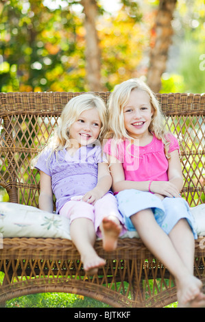 Soeurs assis sur son fauteuil de jardin Banque D'Images