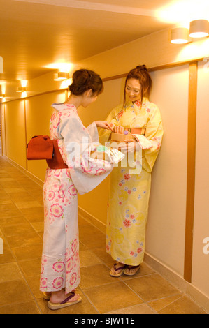 Les femmes portant un yukata debout dans le couloir parler de health spa Banque D'Images