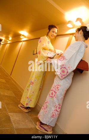 Les femmes portant un yukata debout dans le couloir parler de health spa Banque D'Images