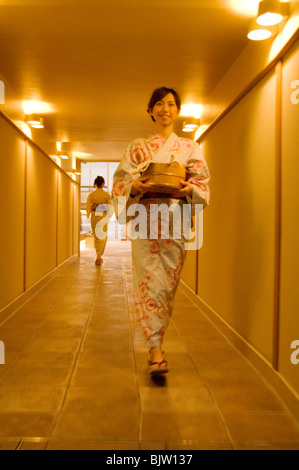 Deux femmes portant un yukata marche à travers le couloir d'un spa de santé Banque D'Images