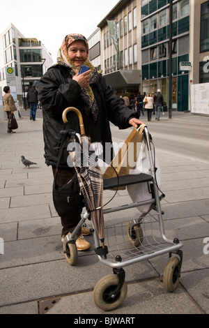 Une femme porte un foulard (hijab) et utilise un dispositif d'aide à la marche dans la rue d'Ulm en Allemagne. Banque D'Images