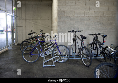 Les vélos verrouillé dans le garage à vélos dans l'enceinte de l'école en Angleterre. Banque D'Images