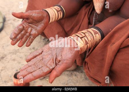 Femme Himba moud Pigment à appliquer sur la peau Banque D'Images