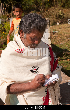 L'Inde, le Tamil Nadu, Nilgiri, Udhagamandalam (Ooty), traditionnellement vêtus Toda aîné tribal écrit dans le bloc-notes Banque D'Images