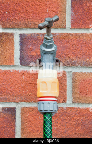 La Grande-Bretagne, Royaume-Uni. Appuyez sur l'extérieur avec connecteur de tuyau flexible et fixé sur un mur de briques Banque D'Images