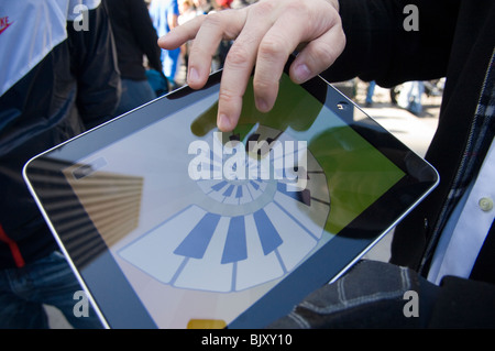 Un iPad démontre l'acheteur d'un instrument de musique l'app pour l'iPad à la sortie de la tant attendue de l'iPad d'Apple. Banque D'Images