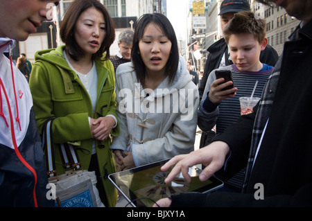 Un iPad démontre l'acheteur d'un instrument de musique l'app pour l'iPad à la sortie de la tant attendue de l'iPad d'Apple. Banque D'Images