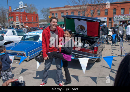 Copain copine Chicana aidant à travers la pièce voiture Lowrider barrière du pavillon. Le Cinco de Mayo Fiesta St Paul Minnesota USA Banque D'Images