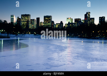 Manhattan vu depuis le lac gelé dans Central Park à New York lors d'une froide soirée d'hiver. Banque D'Images