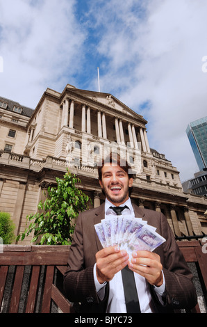Vue verticale d'un business man holding billets de 20 livres à l'extérieur de la Banque d'Angleterre à Londres, Angleterre Banque D'Images
