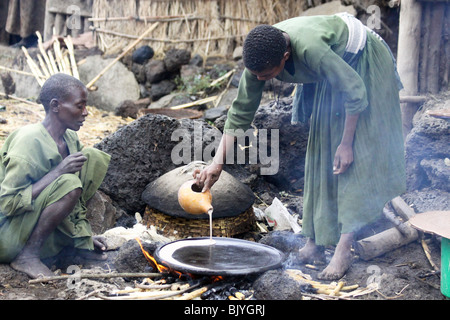 L'Afrique, Ethiopie, Lalibela, Woman cooking Injera (crêpe comme du pain à partir de farine de teff) sur un mogogo sur un feu Banque D'Images