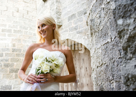 Smiling young bride holding bouquet à l'extérieur Banque D'Images