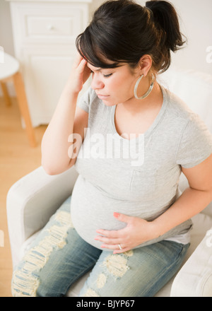 Pregnant Hispanic woman avec maux de tête Banque D'Images