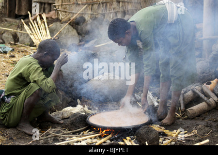 L'Afrique, Ethiopie, Lalibela, Woman cooking Injera (crêpe comme du pain à partir de farine de teff) sur un mogogo sur un feu Banque D'Images