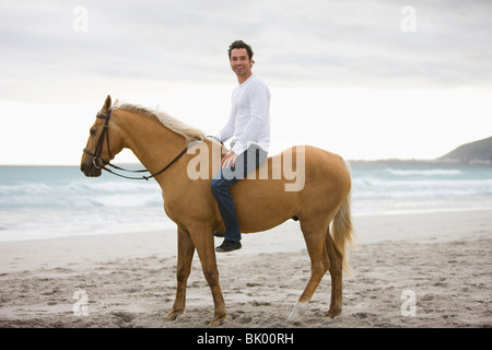 L'homme cheval d'équitation sur la plage Banque D'Images