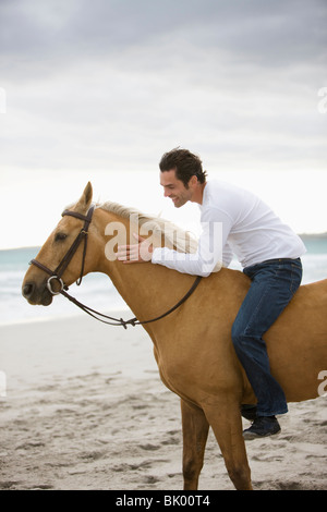 L'homme cheval d'équitation sur la plage Banque D'Images