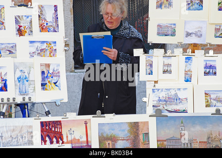 Une femme vente de peintures pour les touristes à Venise, Italie Banque D'Images