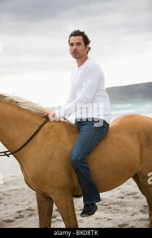 L'homme cheval d'équitation sur la plage Banque D'Images