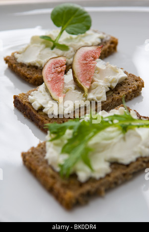 Pain de seigle pumpernickel canapes sur une plaque blanche. Banque D'Images