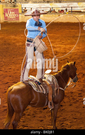 Guadalajara, Mexique, Charro (Cowboy) truc Roper debout sur l'exécution à l'Charreda Festival & Rodeo Show, Lienzo Banque D'Images