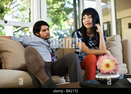 Couple de vous détendre sur un canapé dans la salle de séjour Banque D'Images