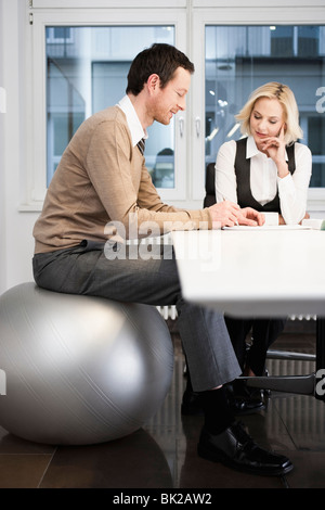 Businessman sitting on fitness ball Banque D'Images
