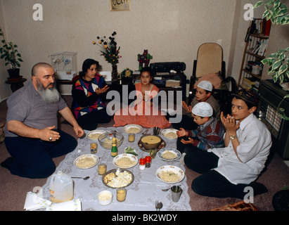 Clapton Londres - famille musulmane pendant le Ramadan prier avant de manger Banque D'Images