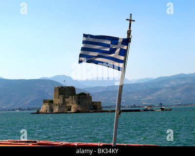 Nauplie, Péloponnèse, Grèce drapeau grec sur le bateau au-delà de Château de Bourtzi Banque D'Images