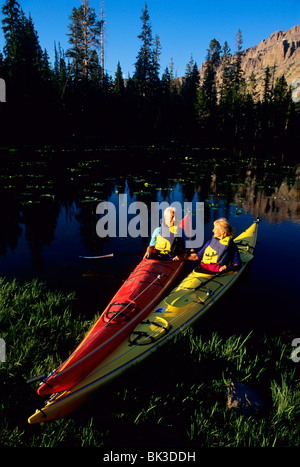 Un couple sain et actif, des kayaks au bord d'un lac dans les montagnes du nord de l'Uinta dans l'Utah. Banque D'Images