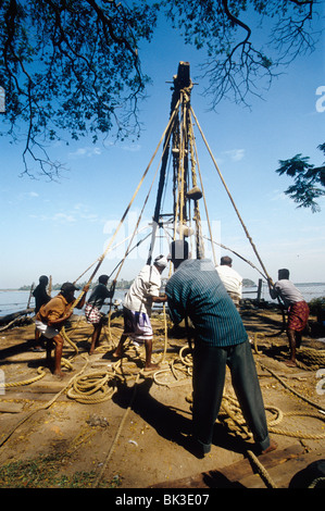 Les pêcheurs travaillant sur les filets de pêche chinois à fort Cochin Kerala Inde Banque D'Images