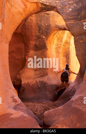 Une femme admire la lumière chaude dans le Ravin de Peekaboo Escalante Canyons de Grand Staircase Escalante National Monument (Utah). Banque D'Images