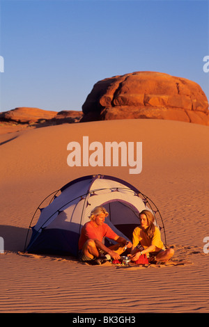 Couple camping dans les dunes de sable blanc au sud de la ville de Green River, dans l'Utah. Banque D'Images