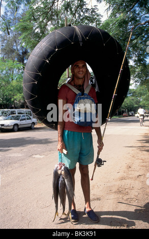 Jeune homme avec le poisson, la canne à pêche, et le tube intérieur gonflable, La Havane, Cuba Banque D'Images