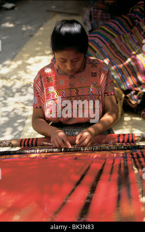 L'ensouple travailler avec des textiles en rouge une aide à tisser, Guatemala Banque D'Images