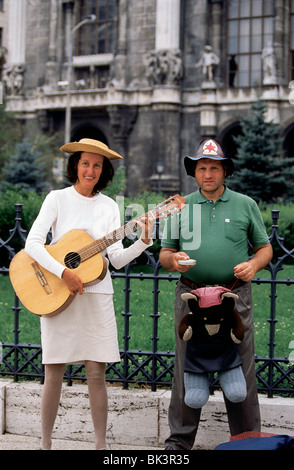 Portrait d'une femme avec une guitare et d'un homme avec un animal farci comme artistes de rue à Budapest, Hongrie Banque D'Images