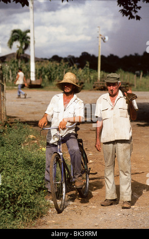 Deux cubains l'un avec un vélo et d'autres tenant un fusil et fumer un cigare près de Soroa Vallée de Vinales province de Pinar del Rio Cuba Banque D'Images